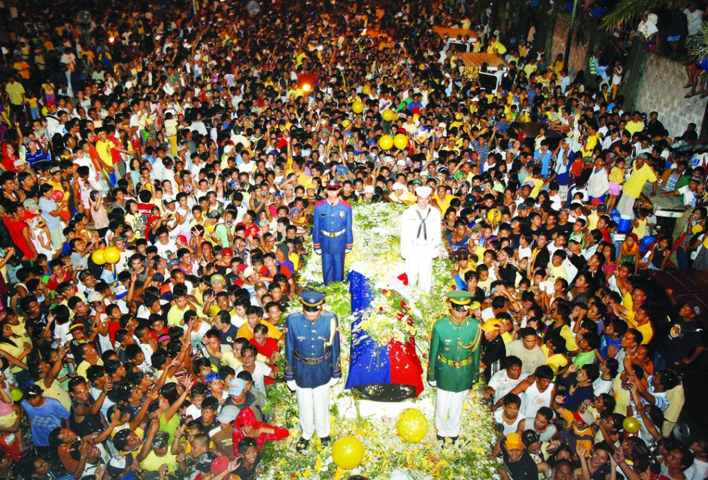 Thousands watch the cortege of former President Cory Aquino along Sucat road in Paranaque City. MANNY MARCELO/PHOTO