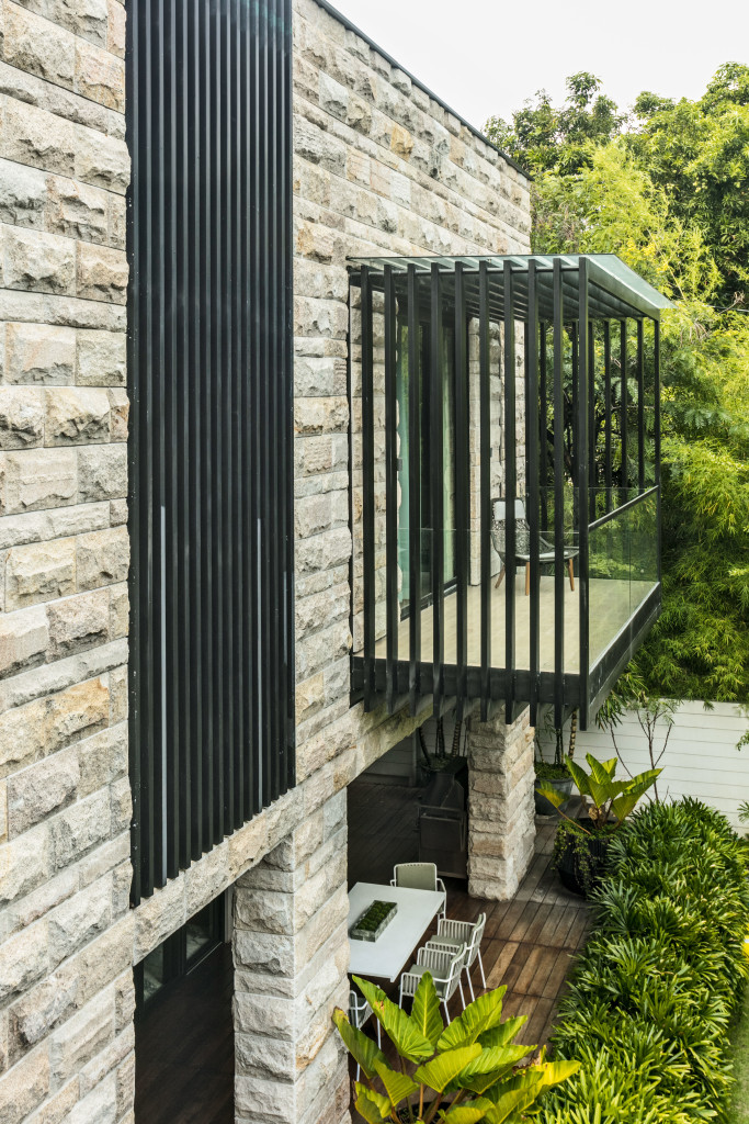 A cantilevered balcony with glass and wood railings